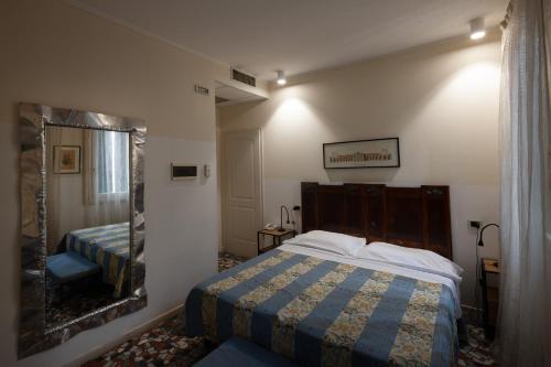 a bedroom with a bed and a large mirror at CityHotel Cristina Vicenza in Vicenza