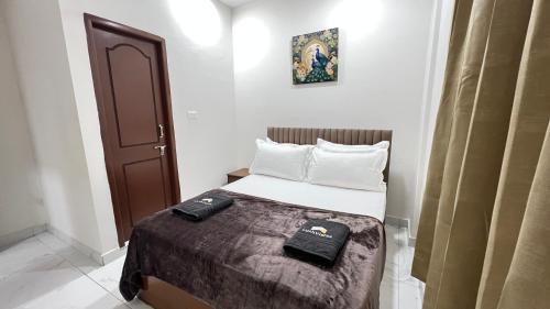 a small room with a bed with two towels on it at Abode Stayz Madhapur in Hyderabad