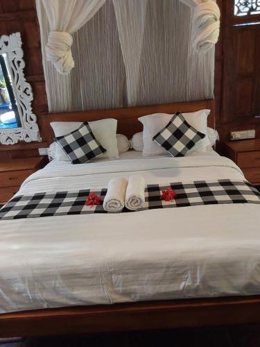 a bed with black and white checkered towels on it at Buratwangi Joglo House in Kerobokan