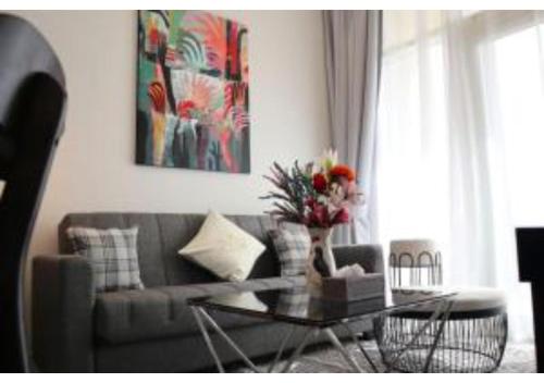 a living room with a couch and a glass table at Oasis 1BR Escape - Chic & Relaxing Apartment in Abu Dhabi