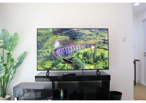 a flat screen tv on a wall in a living room at Oasis 1BR Escape - Chic & Relaxing Apartment in Abu Dhabi