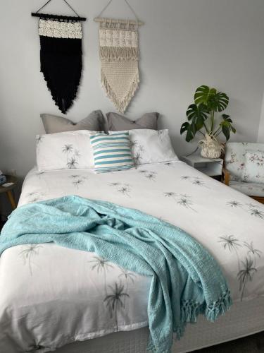 a bedroom with a bed with a blue blanket on it at Sunny flat 5 minute walk to town in Motueka
