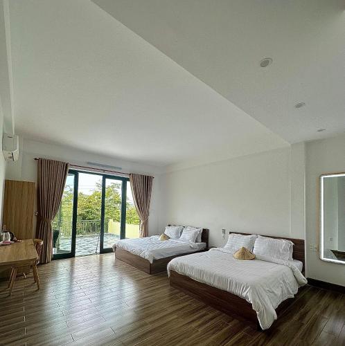 a large room with two beds and a table at Gạo Homestay-Hue in Hue