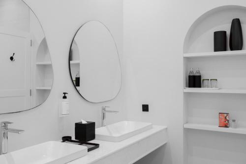 a white bathroom with two sinks and a mirror at The Gems Mining Pool Villas Pattaya in Nong Prue