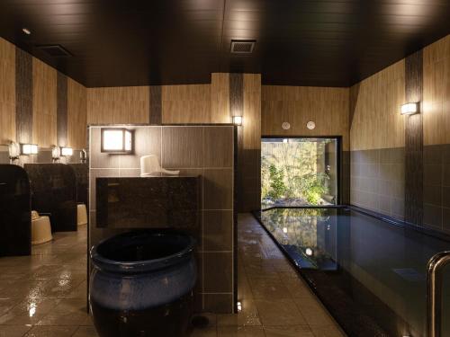 a bathroom with a swimming pool and a toilet at Hotel Route Inn Kurayoshi Ekimae in Kurayoshi