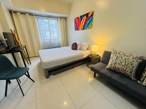 a small bedroom with a bed and a couch at Brenthill Premium Condo Baguio City with Generator in Baguio