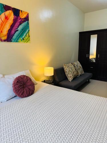 a bedroom with a large bed and a couch at Brenthill Premium Condo Baguio City with Generator in Baguio