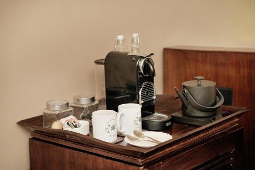 a table with a coffee maker and cups on it at Aalia Jungle Retreat and Spa, Bandarjudh, Haridwar - Araiya Anthology in Dehradun