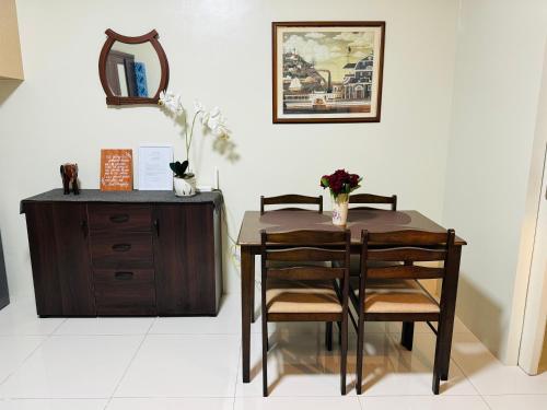 a dining room table with two chairs and a dresser at Brenthill Premium Condo Baguio City with Generator in Baguio