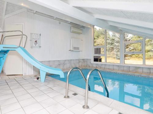 a swimming pool with a blue slide next to a swimming pool at 9 person holiday home in Jerup-By Traum in Jerup