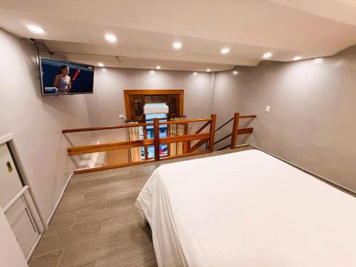 a bedroom with a bed and a tv on the wall at Casa Recoleta - Hoteles Recoleta in Buenos Aires