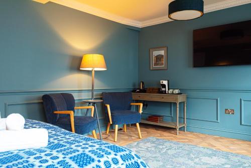 a bedroom with a bed and a desk with chairs at Central Whitchurch - Lowcross House Guest Bedroom 1 in Whitchurch