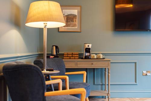 a room with a desk with chairs and a lamp at Central Whitchurch - Lowcross House Guest Bedroom 1 in Whitchurch