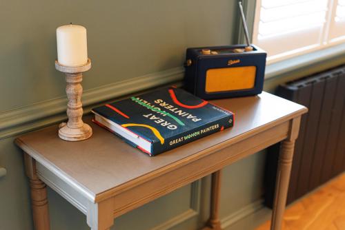 a table with a book and a candle on it at Central Whitchurch - Lowcross House Guest Bedroom 1 in Whitchurch