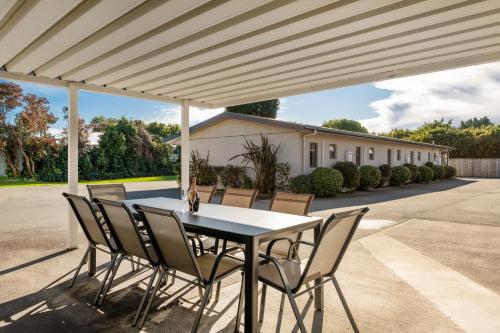 a table and chairs under a pergola at Grove Park Motor Lodge in Blenheim