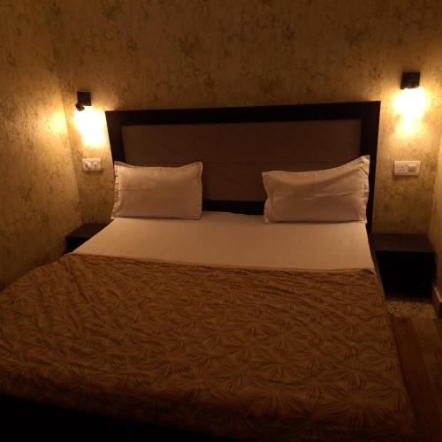 a bedroom with a large bed with two pillows at Shreeji Inn Homestay in Rishīkesh