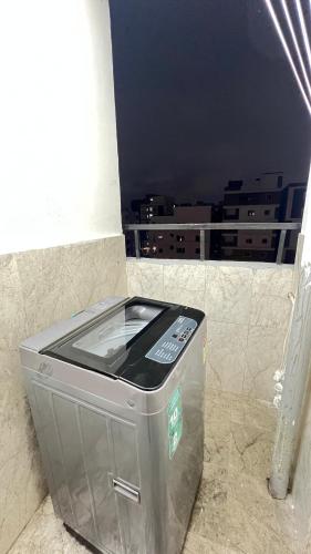 a metal trash can in a room with a window at Abode Stayz Madhapur in Hyderabad