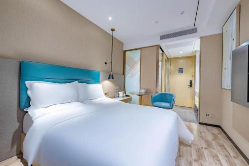 a large white bed in a hotel room at ZMAX Hotels Shenzhen Lianhuacun Metro Station in Shenzhen