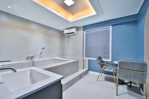 a bathroom with a sink and a chair in it at Namunuelbo Hotel Uhbang Branch in Sambang-dong