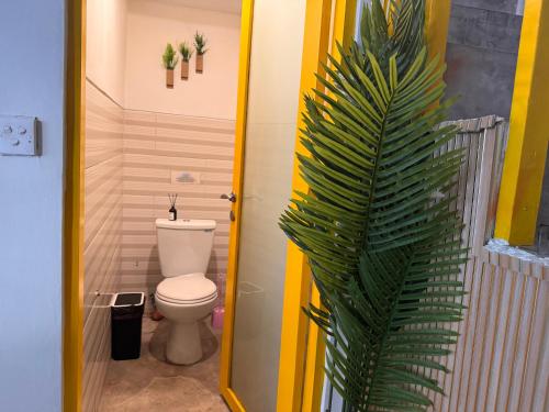a bathroom with a toilet and a palm plant at Palm Villa 5 Seminyak Center in Seminyak