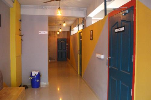 a hallway with colorful walls and a blue door at Tokyo Dorms in Kozhikode