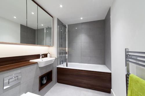 a bathroom with a tub and a sink and a shower at Luxury In2 London Apartment in London