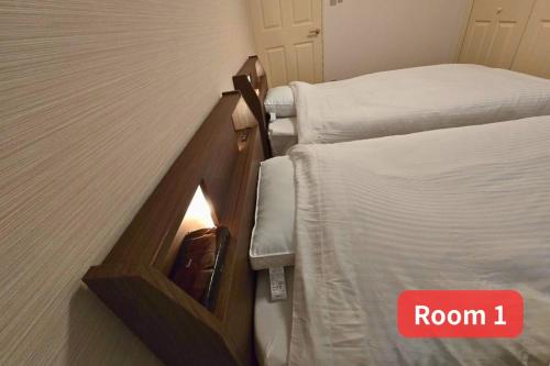 a room with two beds and a sign that says room at Vacation House 2 in Funabashi