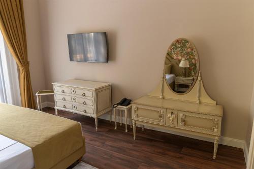 a bedroom with a dresser and a mirror at Tilia Kúria in Bózsva