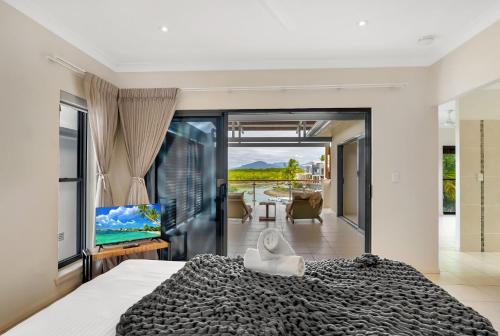 a bedroom with a large bed and a television at Belle Escapes Marina Quay in Yorkeys Knob