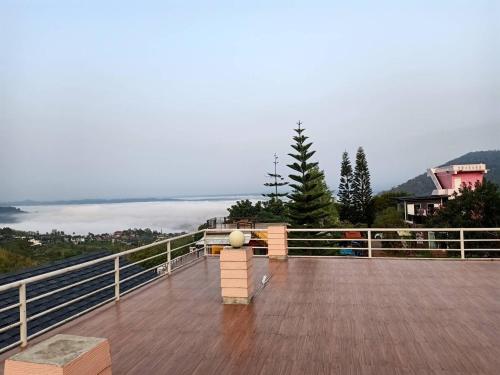 a wooden deck with a bench on top of a mountain at Ban Rai Rabeang Mok in Khao Kho
