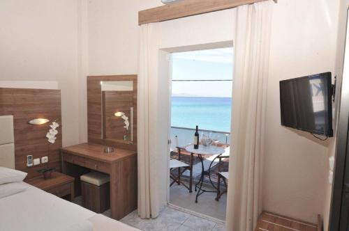 a bedroom with a room with a view of the ocean at Sydney Hotel in Kefalos