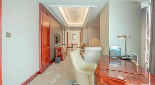a room with a desk and a chair in a room at Dongwu New Century Grand Hotel Huzhou in Huzhou