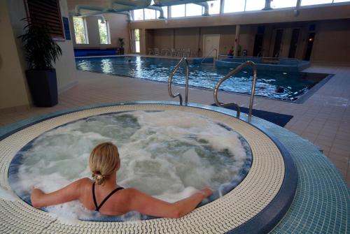 a woman sitting in a bath tub in a swimming pool at Kenmare Bay Hotel Lodges in Kenmare