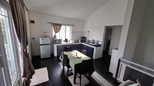 eine kleine Küche mit einem Tisch, einem Tisch und Stühlen in der Unterkunft Résidence La Montagne in Saint Gabriel