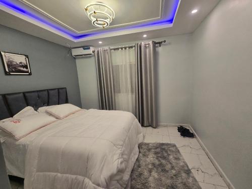 a bedroom with a large bed with a blue lighting at KA residence in Yaoundé