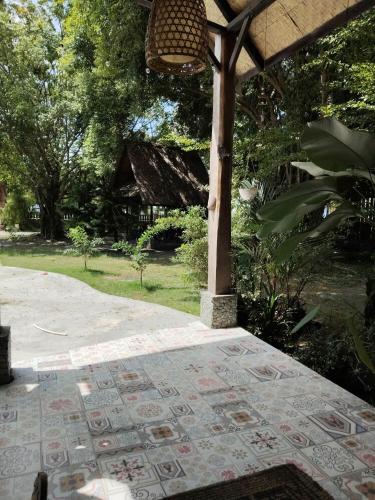 an outdoor patio with a table and an umbrella at Kahyangan hotel in Dondo