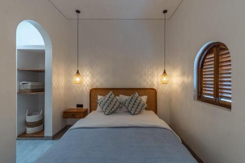a bedroom with a bed with two pillows at The Lotus Backyard Uluwatu in Badung