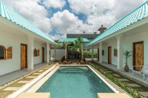 a villa with a swimming pool in front of a house at The Lotus Backyard Uluwatu in Badung