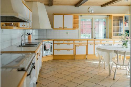 een keuken met witte kasten en een tafel. bij Creative Hideaway By Hållsviken Bay in Trosa