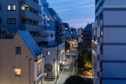 a city street at night with buildings and street lights at Sugamo Winco Residence 新宿まで電車14分 巣鴨駅徒歩3分 光wifi エレベーター 商店街徒歩4分 in Tokyo