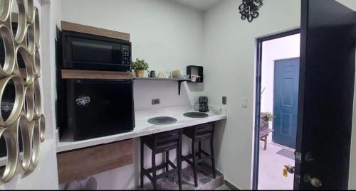 a kitchen with a stove and a microwave at Hospedaje Galeria 76 in Hermosillo