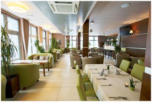 Hotel Polonez في كراكوف: غرفة طعام مع طاولات وكراسي ونوافذ
