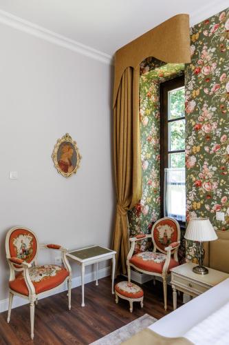 a room with two chairs and a window at Tilia Kúria in Bózsva