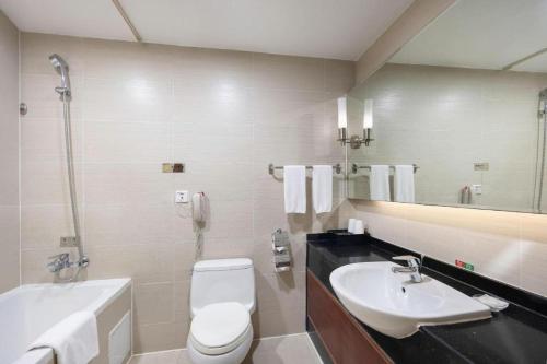 a bathroom with a sink and a toilet and a tub at Linyi Blue Horizon Intenational Hotel in Linyi
