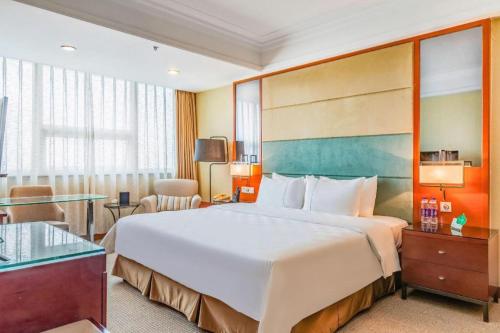 a hotel room with a large bed and a table at Linyi Blue Horizon Intenational Hotel in Linyi
