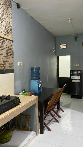 a kitchen with a black table and chairs in a room at LA LUNA Guest House in Banyuwangi