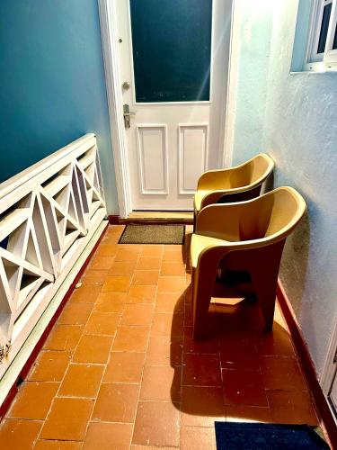 two chairs sitting in front of a door at Gorgeous 1 Bedroom Gem at Negril 7Miles Beach Point Village 