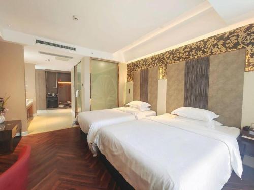 a hotel room with two beds and a room with at Jinjiang Metropolo Hotel - Taizhou Wanda Plaza in Taizhou