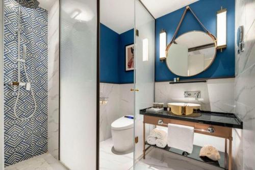 a bathroom with a toilet and a mirror at Jinjiang Metropolo Hotel - Taizhou Wanda Plaza in Taizhou