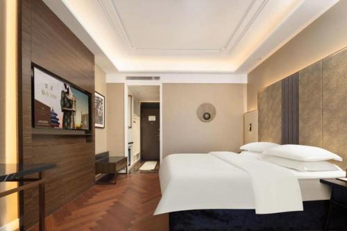 a bedroom with a large white bed in a room at Jinjiang Metropolo Hotel - Taizhou Wanda Plaza in Taizhou